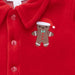 Red jumpsuit with a gingerbread man patch on a red background