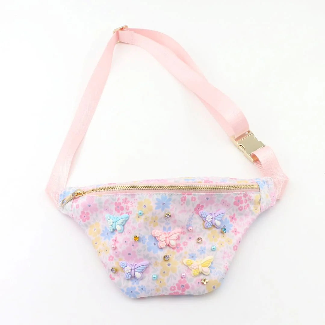 Floral and butterfly patterned fanny pack with pink strap on a white background