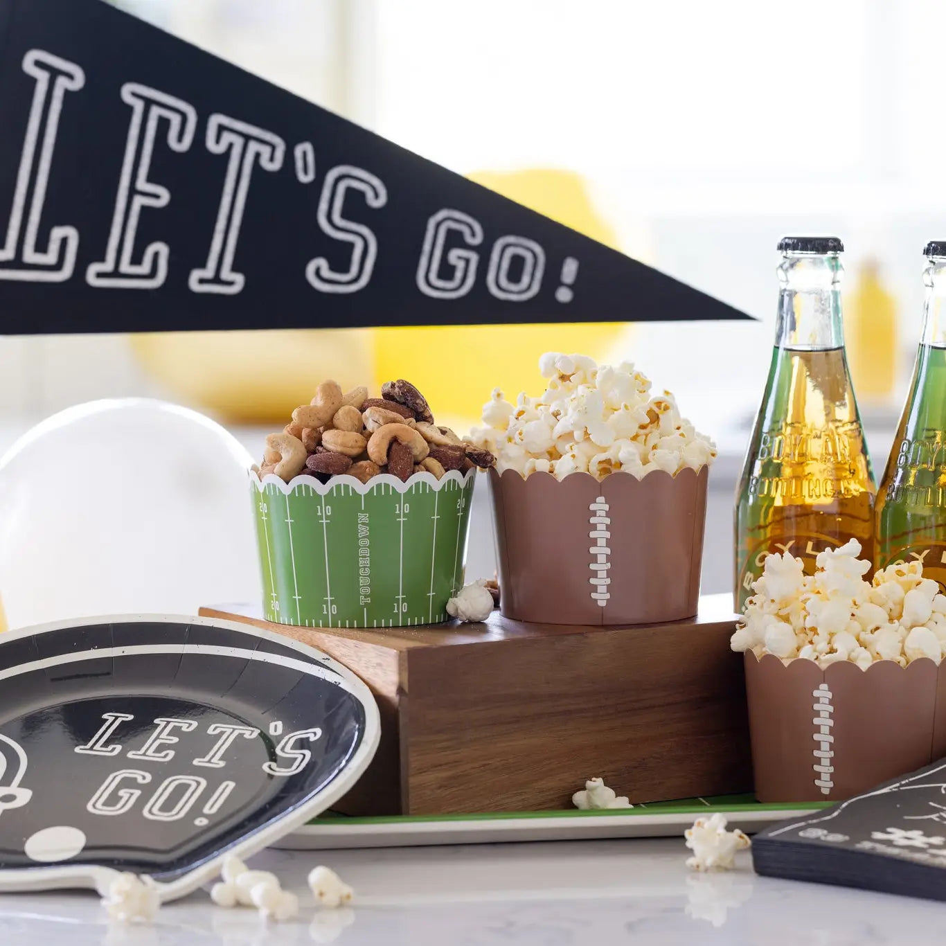 Sports-themed snacks and drinks with 'Let's Go!' banner and decor on a table.