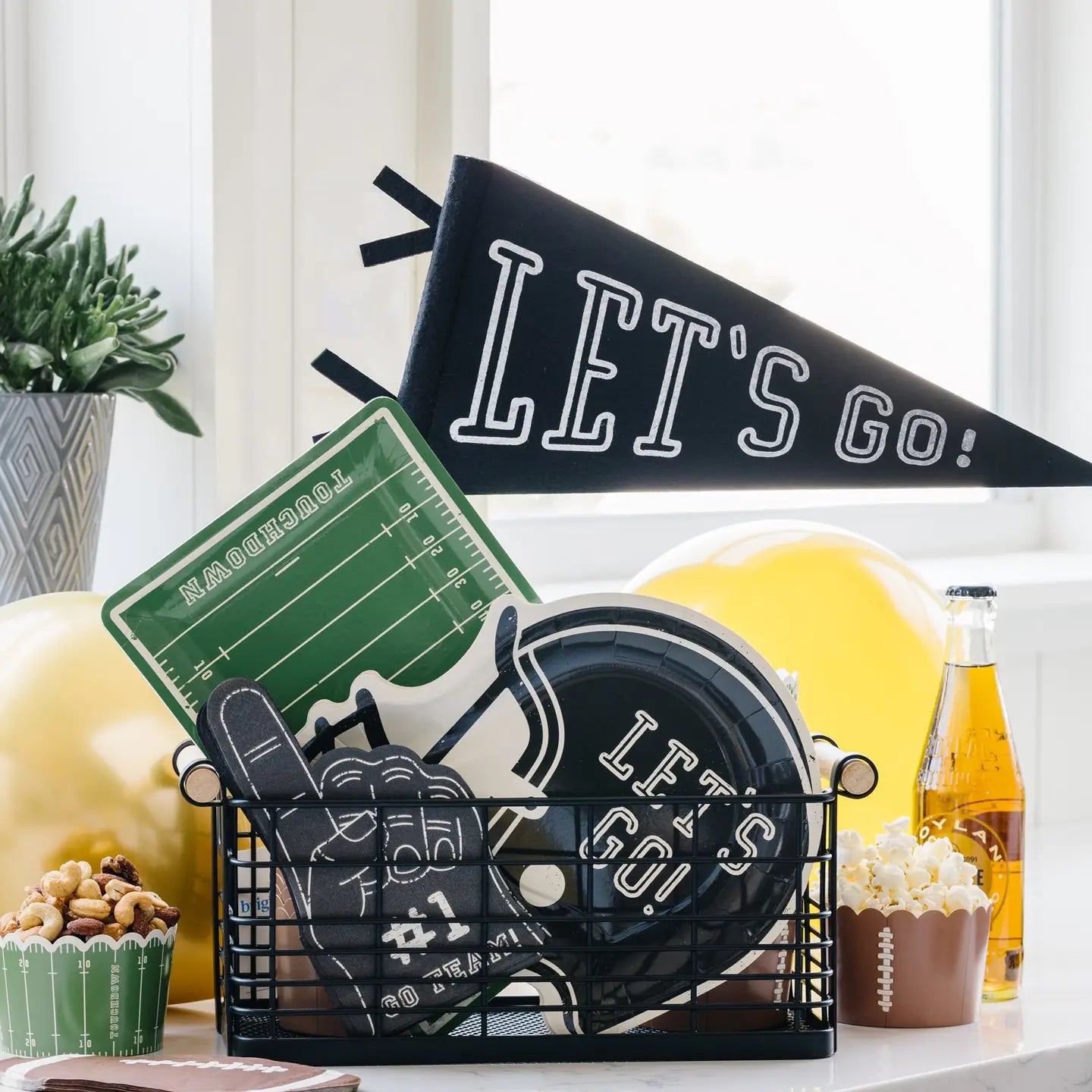 Sports-themed decor items including a 'Let's Go' banner, football helmet, and snacks on a table.