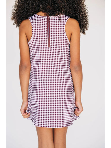 Person wearing a sleeveless checkered dress on a white background