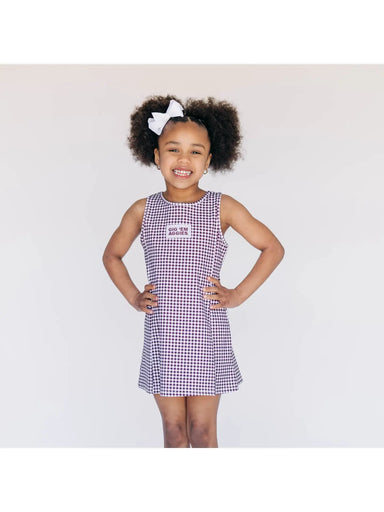 Young girl wearing a checkered dress with a white background