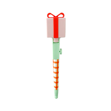 A novelty pen shaped like a gift box, featuring a pale pink box with a red ribbon and bow on top, a mint green body, and orange-and-white diagonal stripes on the lower section, shown against a plain white background.