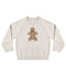 A cream-colored knit crewneck sweater featuring a brown gingerbread man graphic on the chest, displayed against a plain white background.