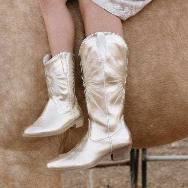 White cowboy boots on a horse with a blurred background