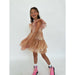 girl wearing blush colored tulle dress covered in gold metallic stars