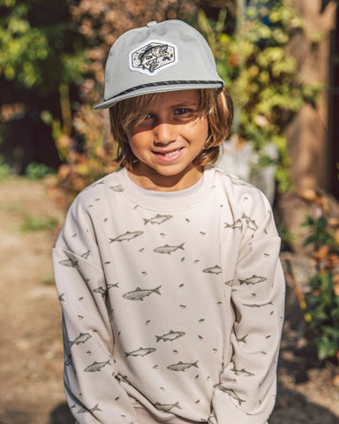 A boy wearing a fish snapback hat