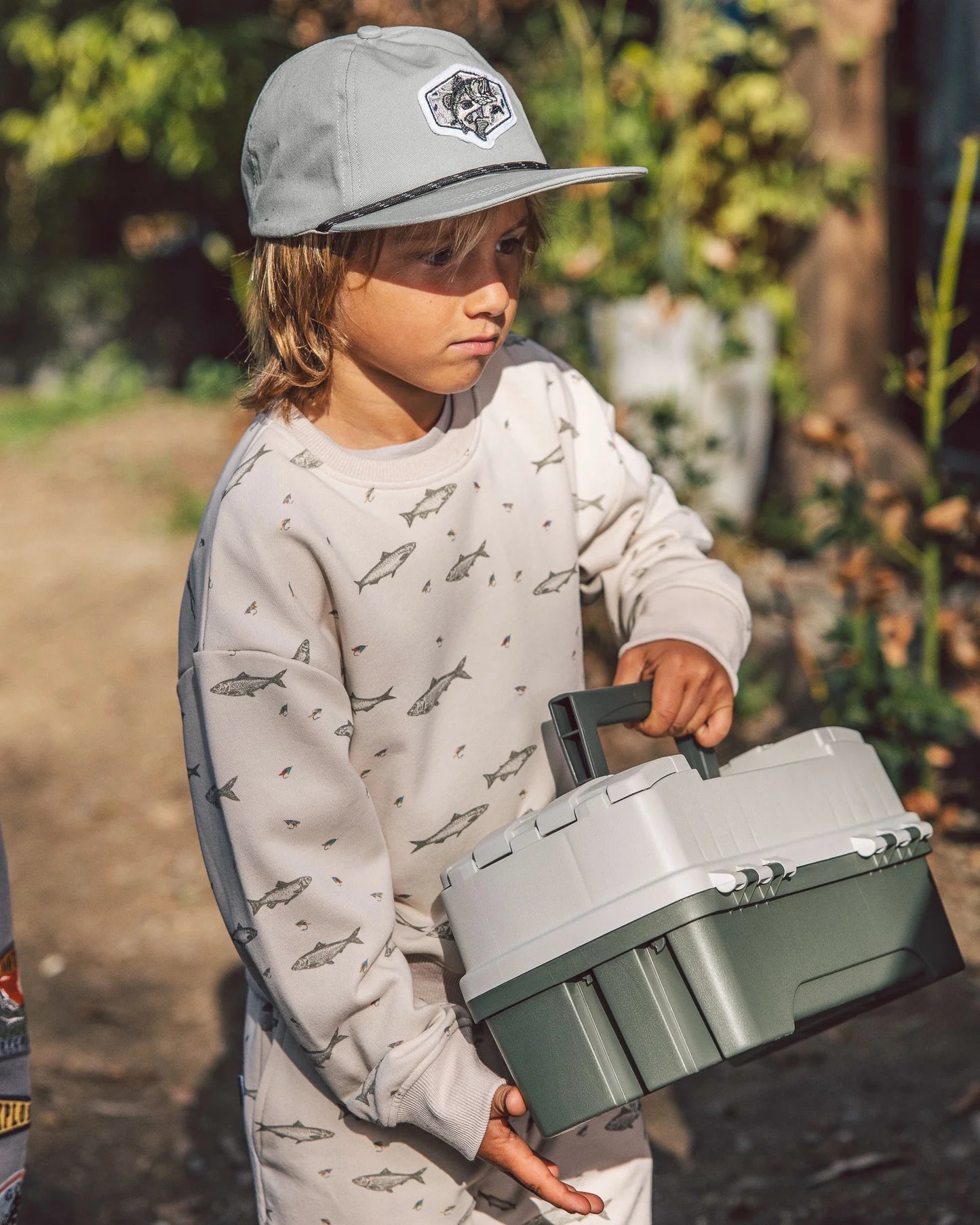A boy wearing a fish snapback hat