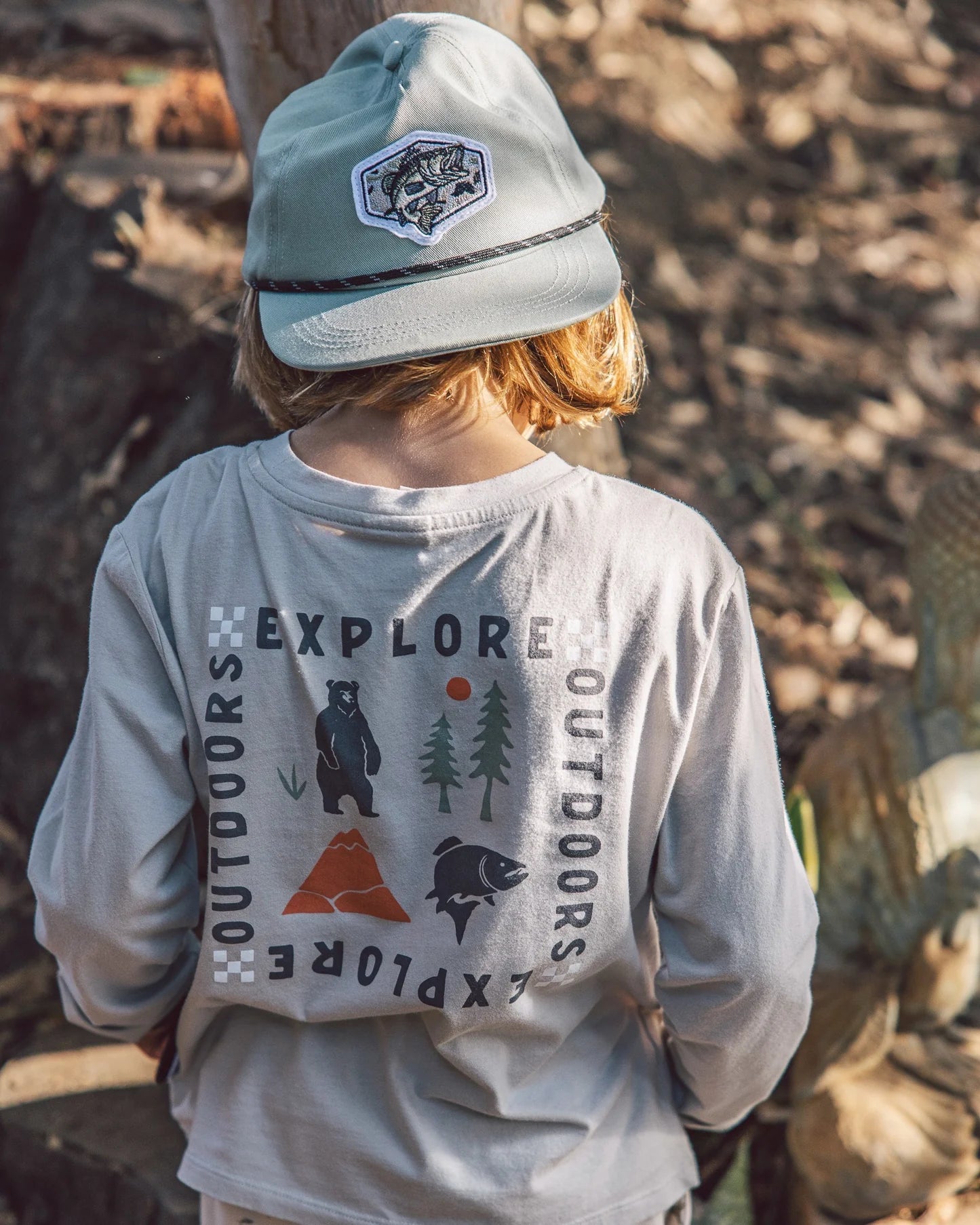 A boy wearing a fish snapback hat