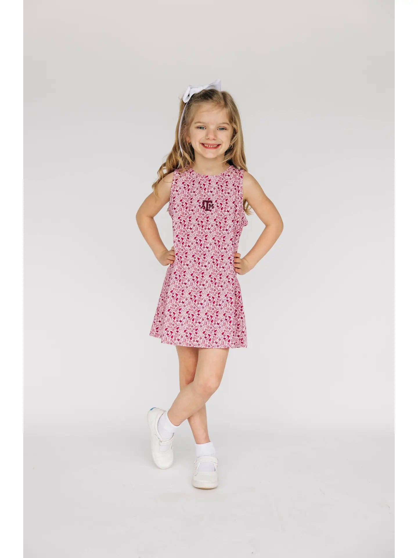 Young girl wearing a maroon A&M dress on a light gray background