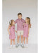 Three children wearing matching outfits with maroon A&M patterns on a white background