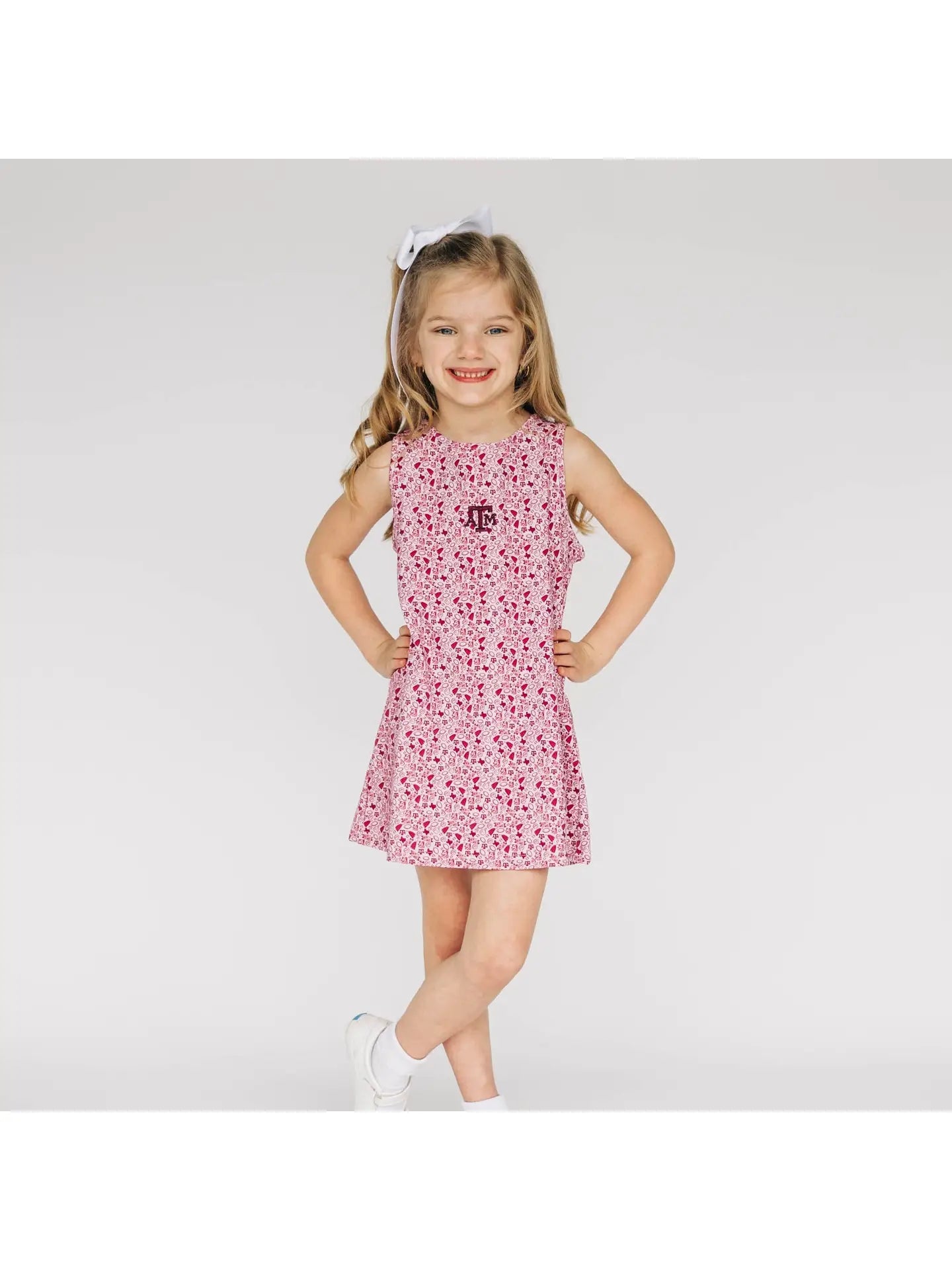 Young girl wearing a maroon A&M dress on a white background