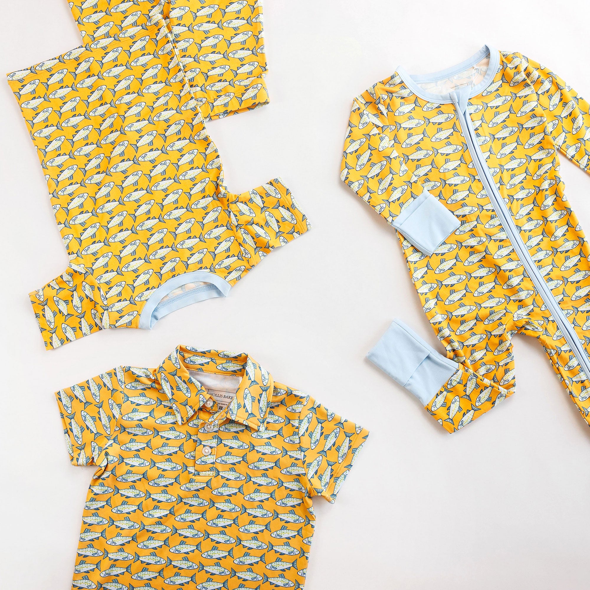 Children's clothing set with yellow and blue fish pattern on a white background