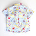 Children's shirt with beach-themed pattern on a white background