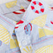 Fabric with nautical pattern including life buoy, sailboats, and shells on a light blue background.