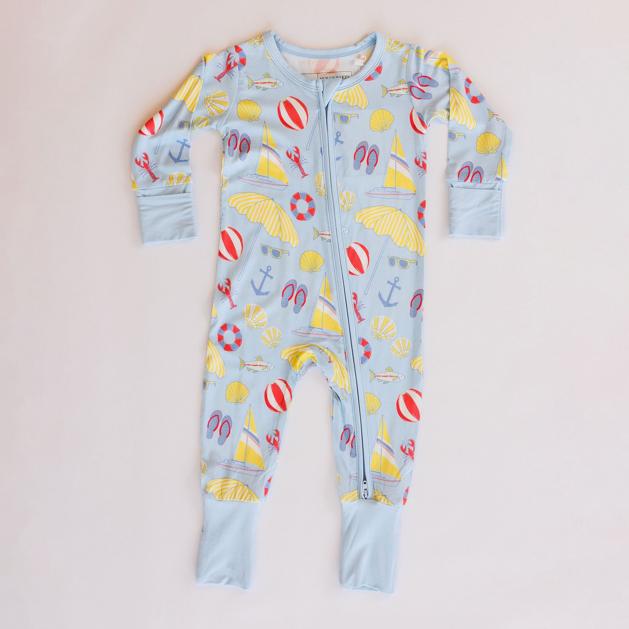 Children's onesie with beach-themed print on a white background