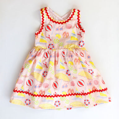 Colorful children's dress with beach-themed pattern on a white background