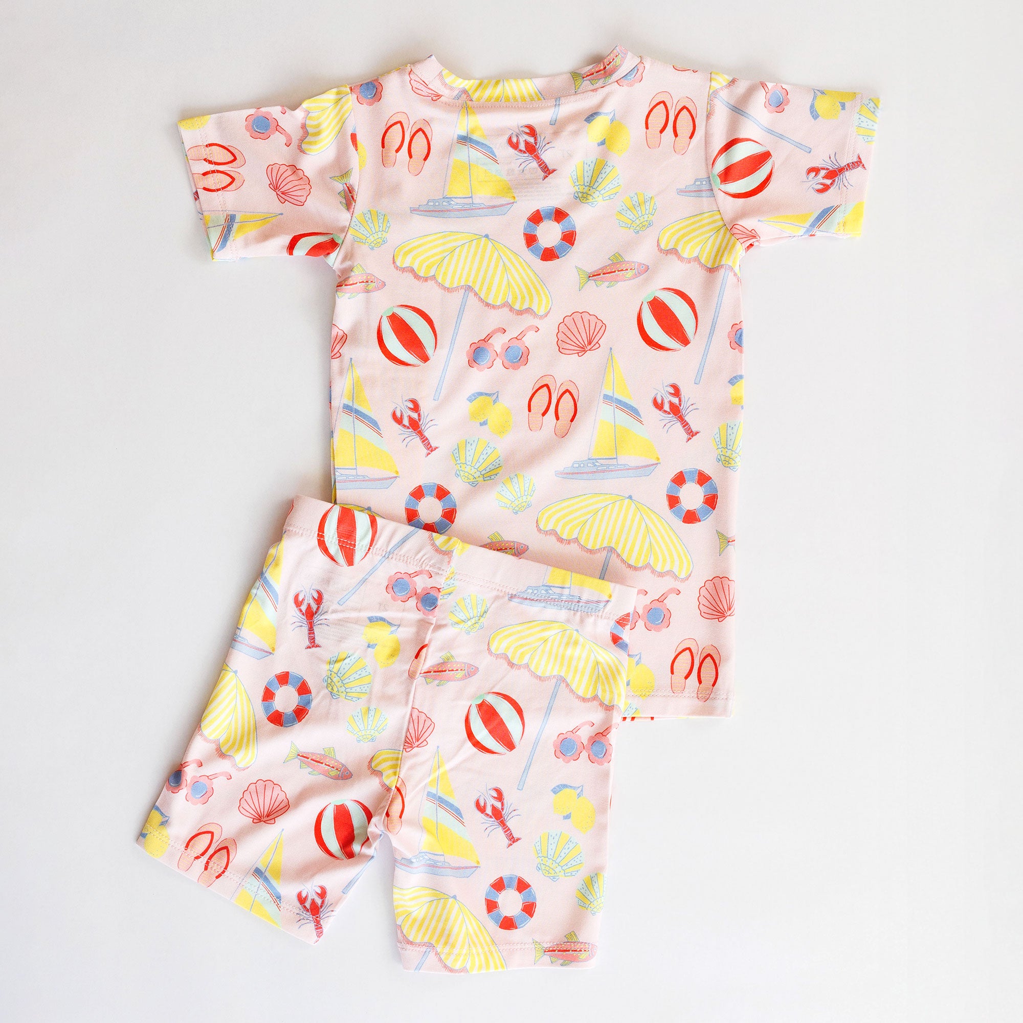 Girl's loungewear set with beach-themed print on a light gray background