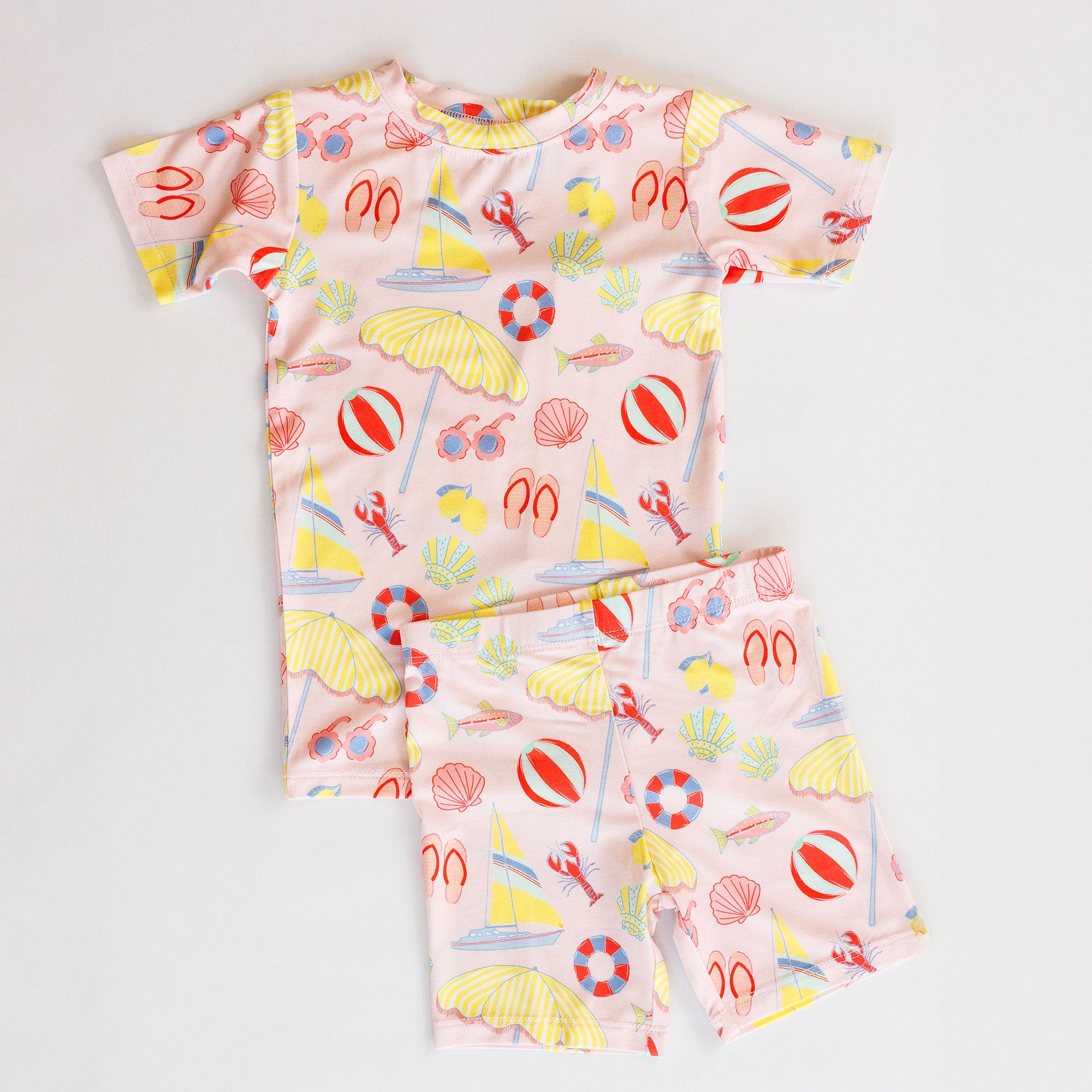 Girl's loungewear set with beach-themed print on a light gray background