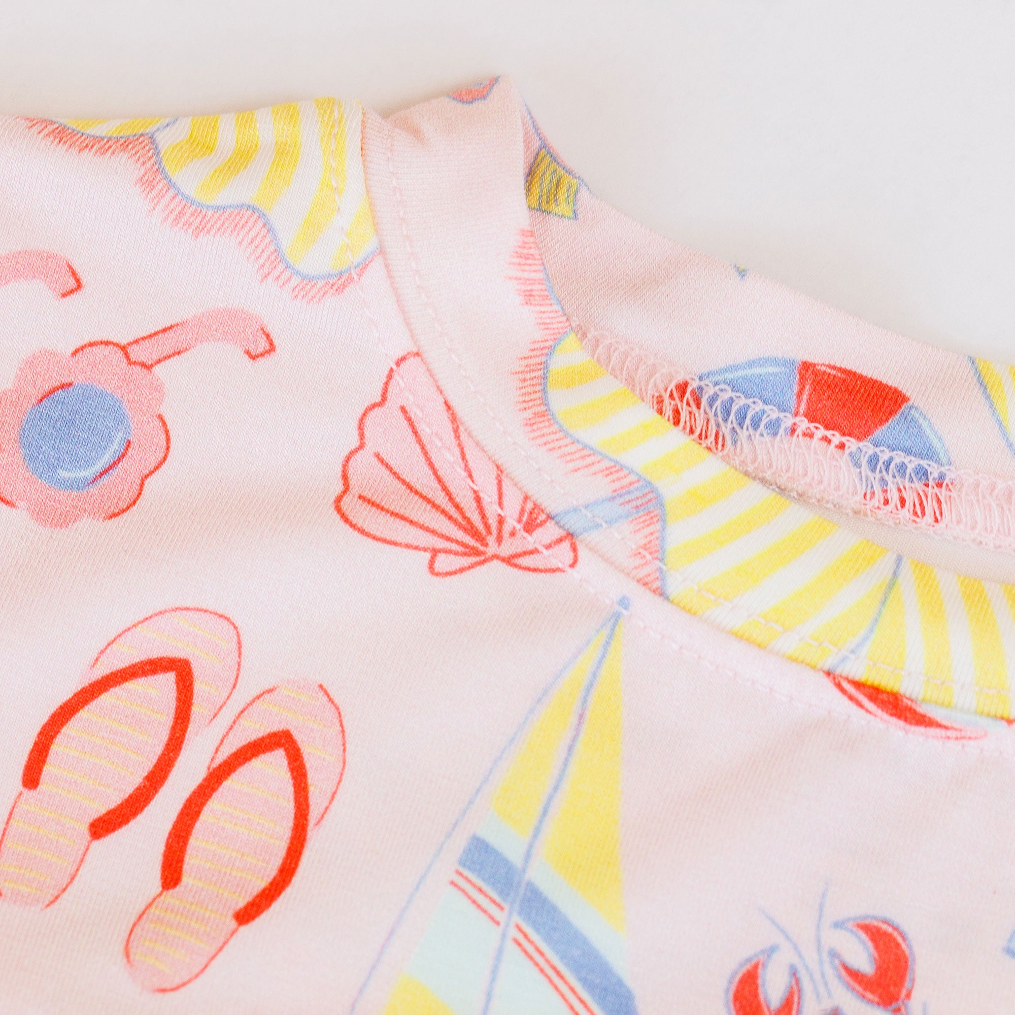 Girl's loungewear set with beach-themed print on a light gray background