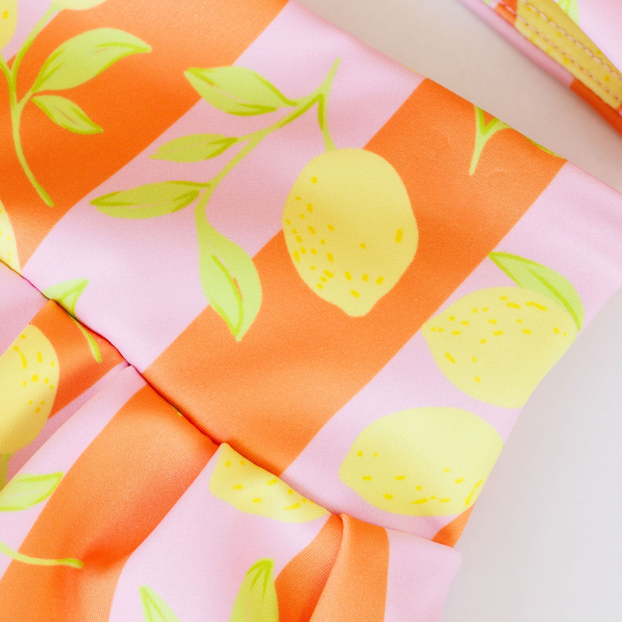 Fabric with lemon pattern on orange, pink, and white background
