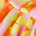 Close-up of fabric with lemon pattern on pink and orange background
