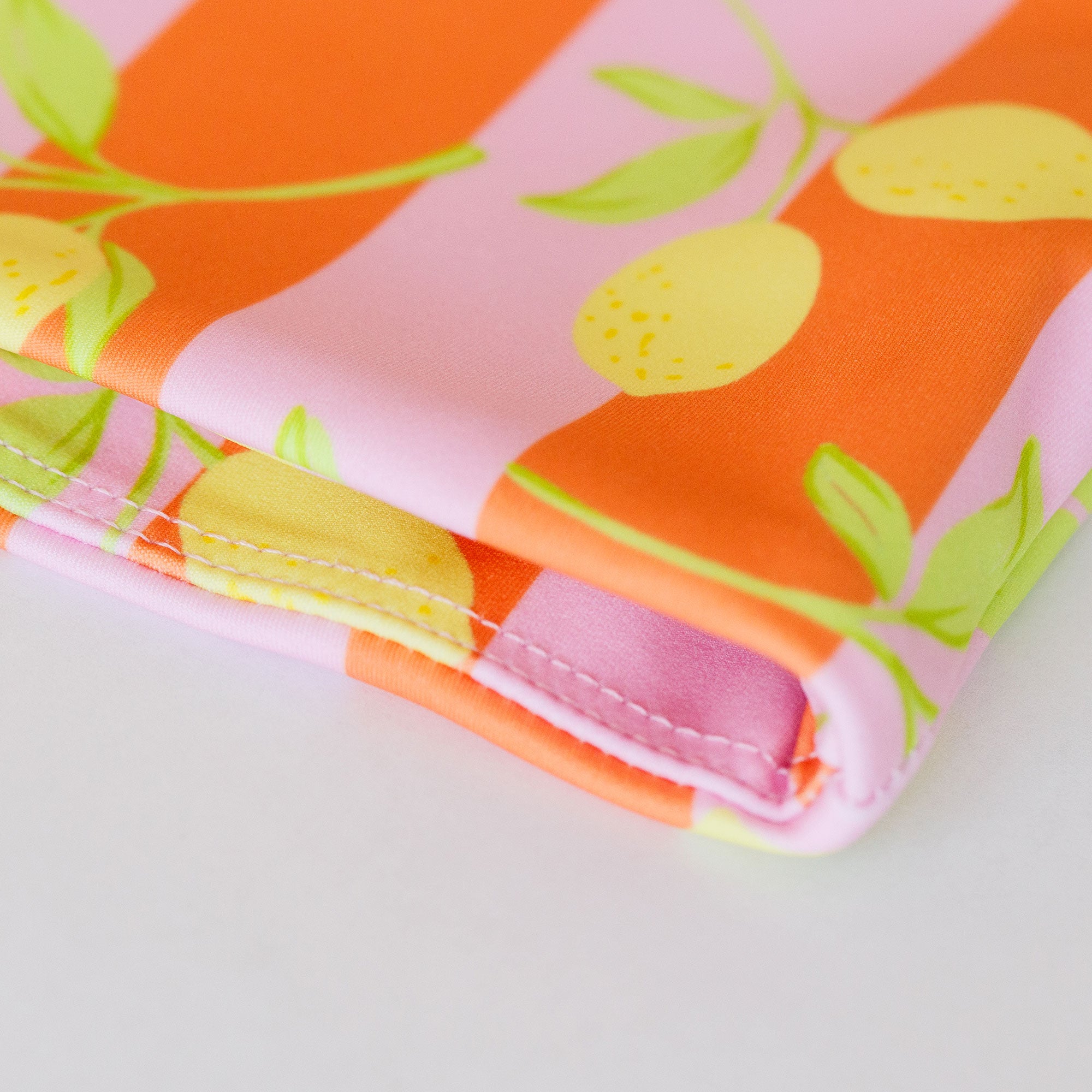 Folded fabric with lemon pattern on an orange and pink background