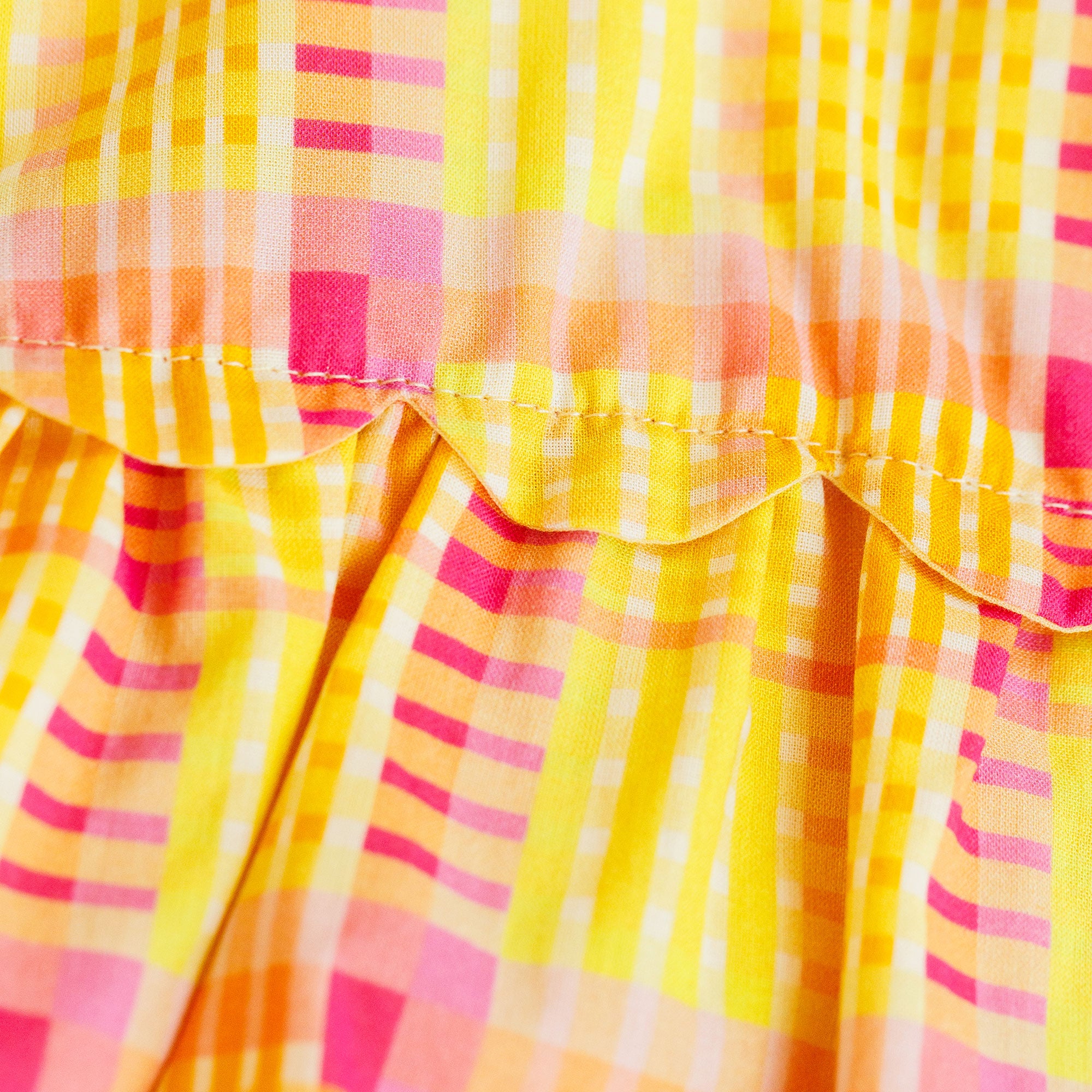 Close-up of a colorful checkered fabric with yellow, pink, and orange patterns.