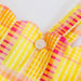 Close-up of a yellow and pink plaid fabric with a button on a white background