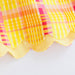 Close-up of a colorful plaid fabric with a scalloped edge on a white background