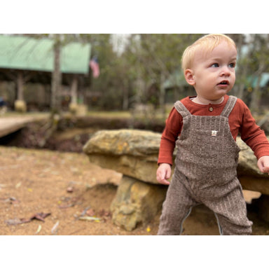 rust colored long sleeve ribbed onesie with brown knit overalls
