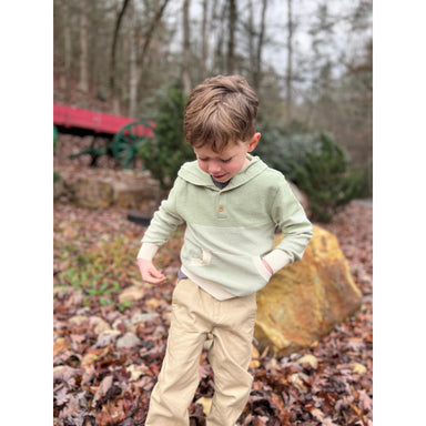 boy wearing sage green hooded sweater with cream colored stripes