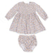 A baby girl's two-piece outfit set consisting of a long-sleeve smocked dress and matching bloomers, featuring a delicate blue and brown floral pattern on a cream background.