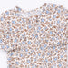 A close-up of a short-sleeve top with a dense floral print featuring light blue flowers and brown leaves on a white background.