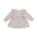 A long-sleeve baby tunic with a ruffled neckline and cuffs, featuring a dense all-over floral print in light blue, brown, and beige on a white background.