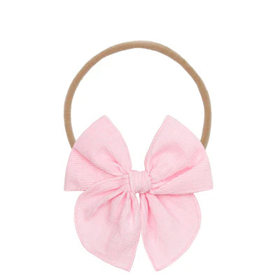Pink bow hair accessory on a white background