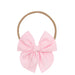 Pink bow hair accessory on a white background