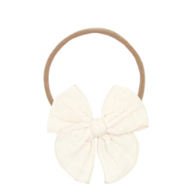 Cream-colored bow headband on a white background