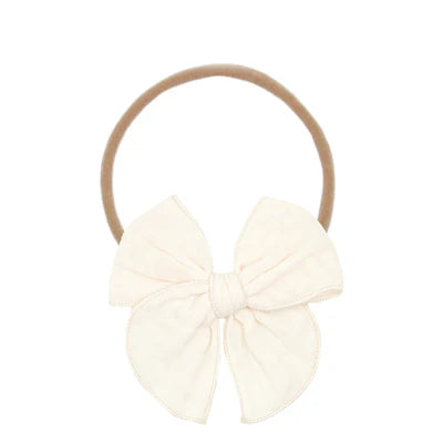 Cream-colored bow headband on a white background