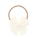 Cream-colored bow headband on a white background
