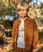 Boy wearing a Hold Your Horses tee under a brown corduroy jacket