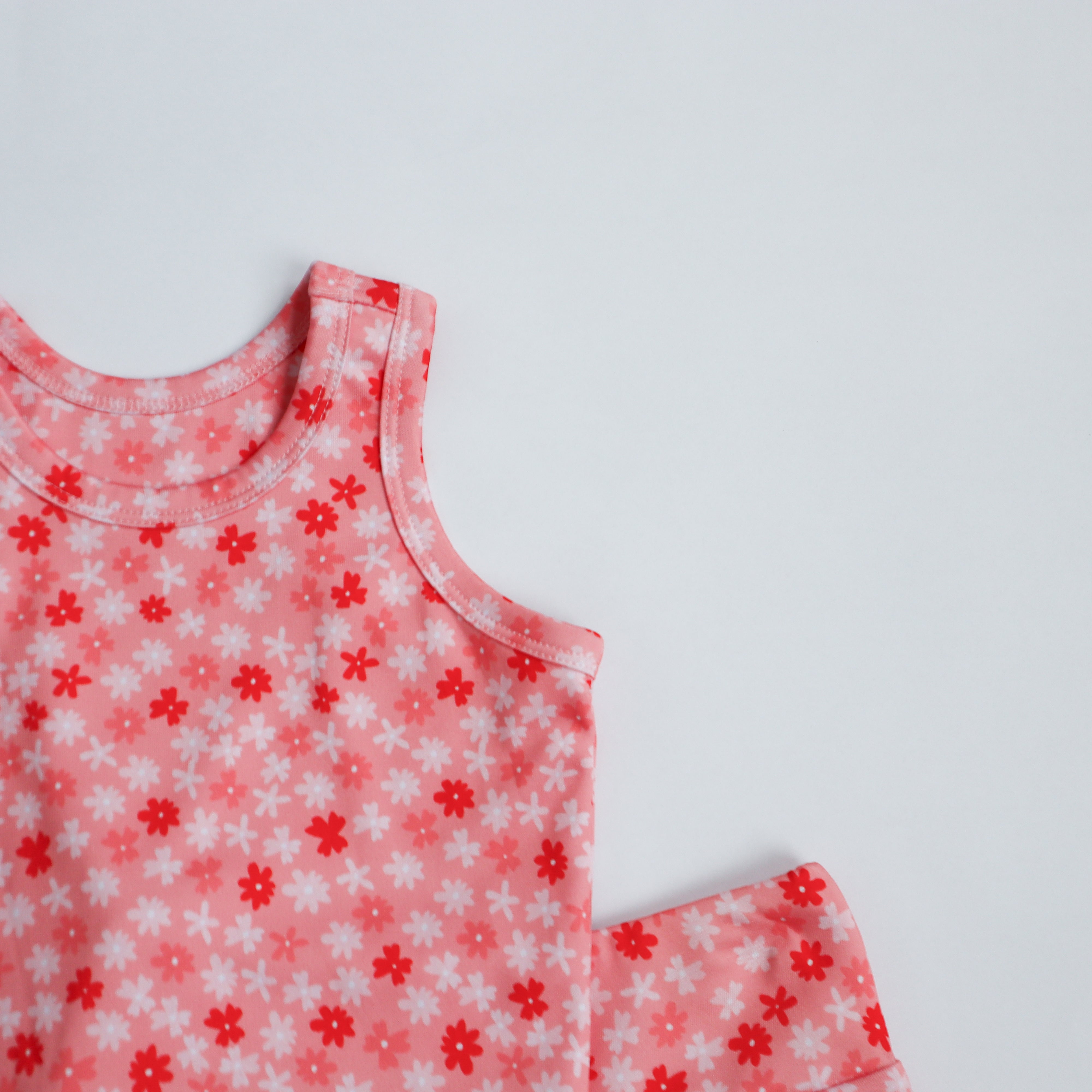 Pink tank top with red and white floral pattern on a pink background