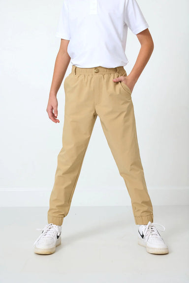 Person wearing beige joggers and white sneakers on a white background