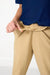 Person wearing a blue shirt and beige pants on a white background