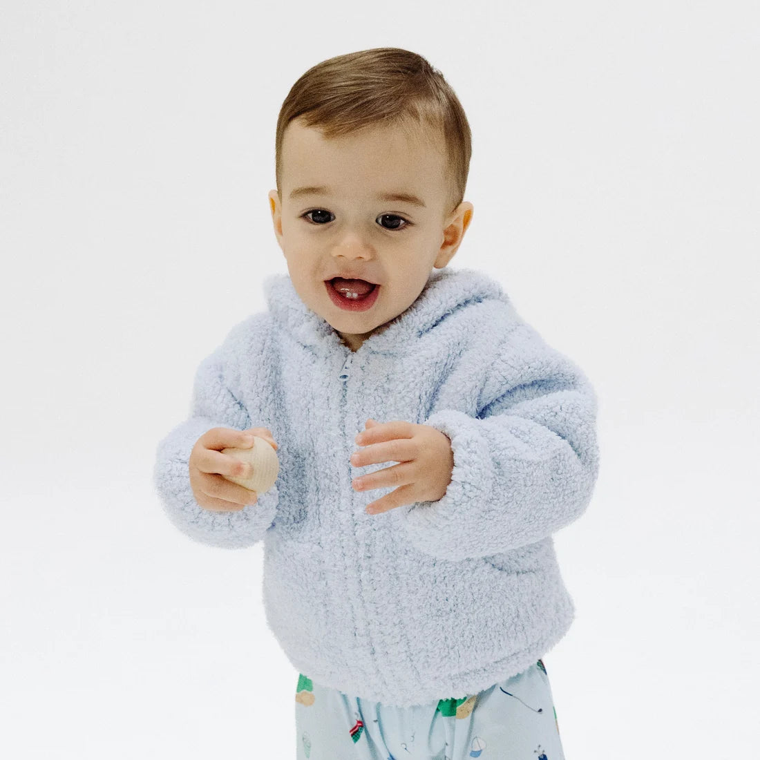 Child wearing a light blue chenille jacket on a white background