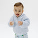 Child wearing a light blue chenille jacket on a white background