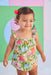 Child wearing a colorful floral bloomer set against a multicolored background