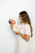 Woman holding a baby against a white background