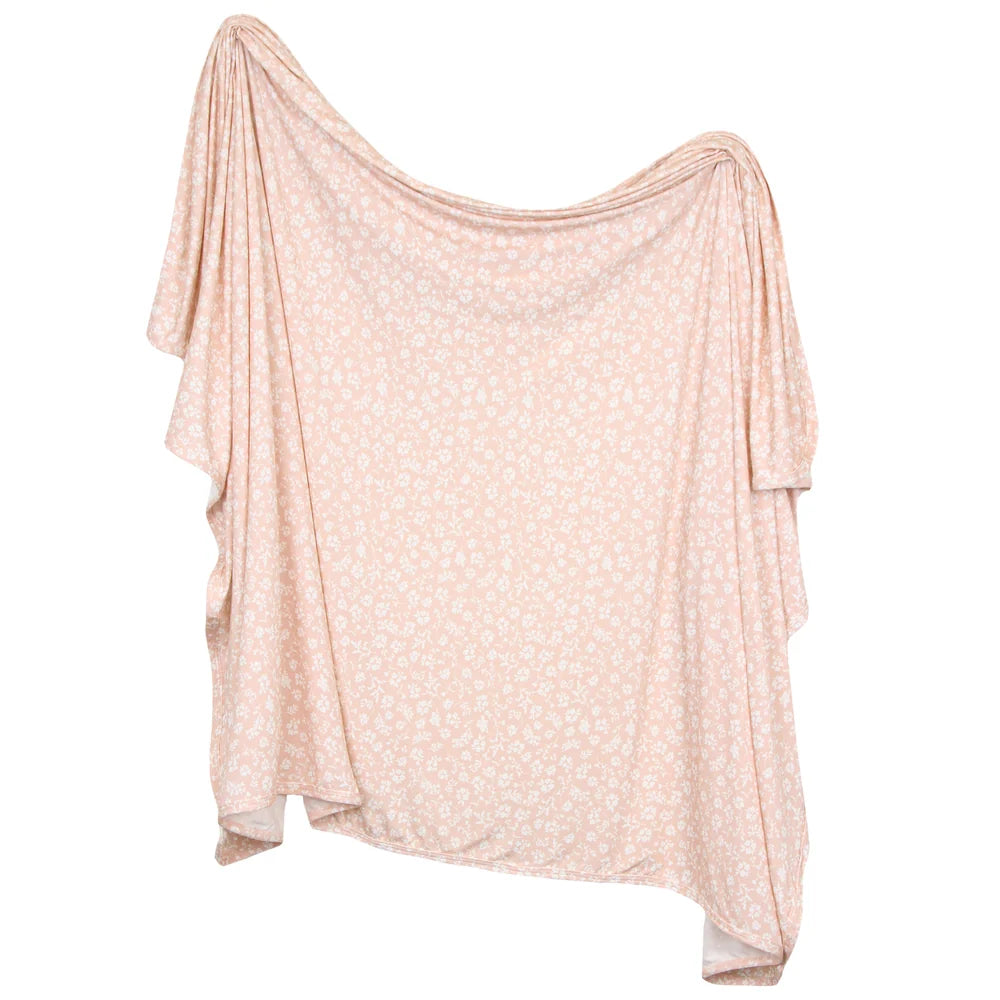 A light pink and white floral print blanket, shown against a plain white background.