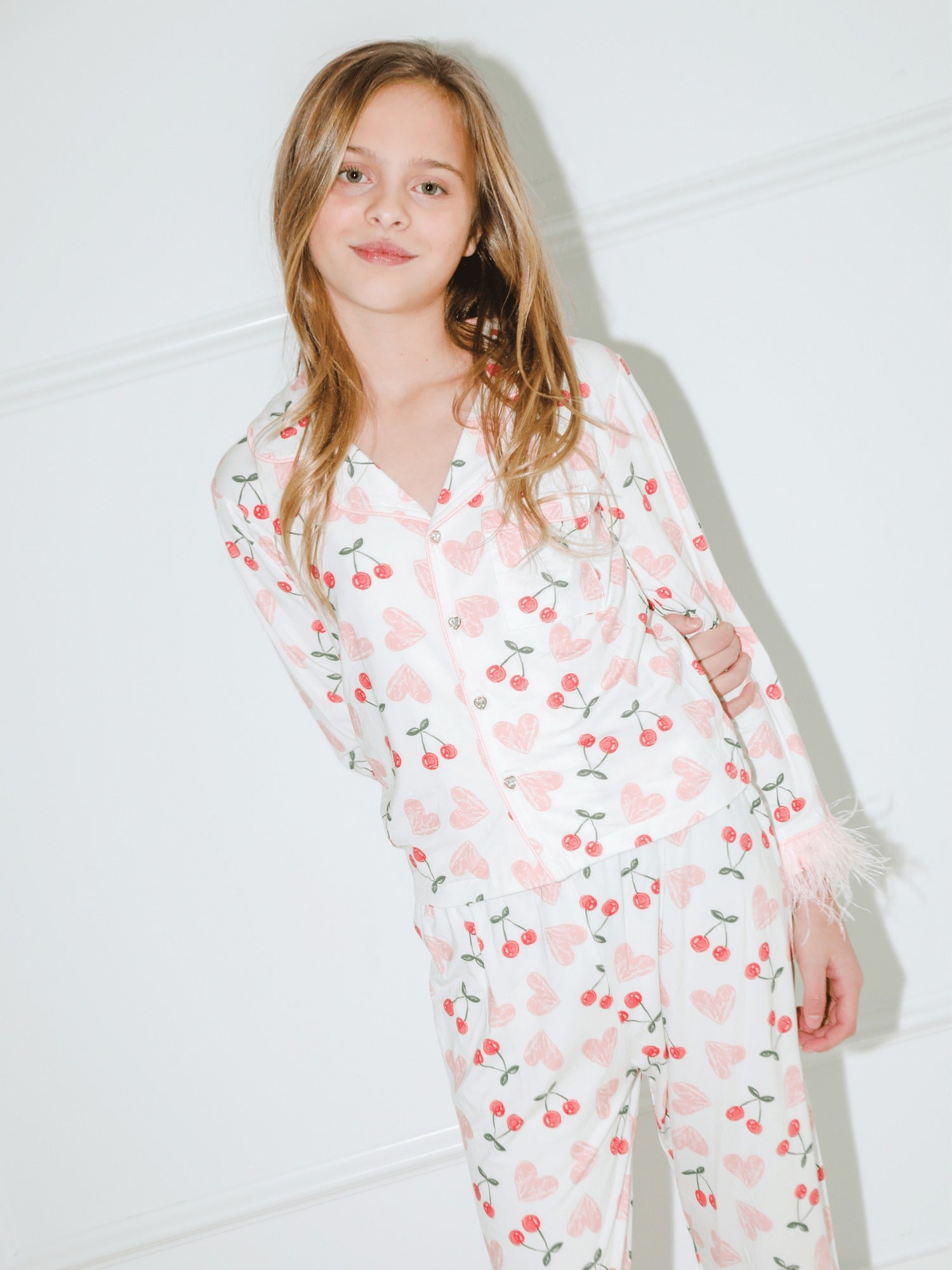 Young girl wearing a floral pajama set against a white background